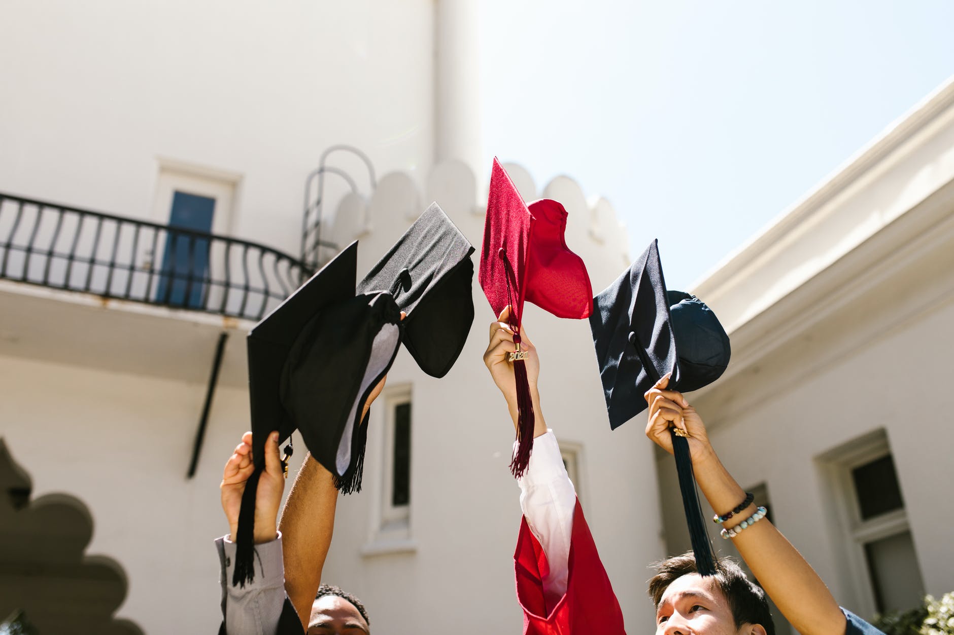 High school seniors holding graduation caps