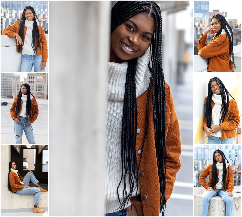 Senior girl wearing dark tan corduroy jacket, white cowl neck sweater, and stonewash destructed jeans standing on the rooftop of a parking garage