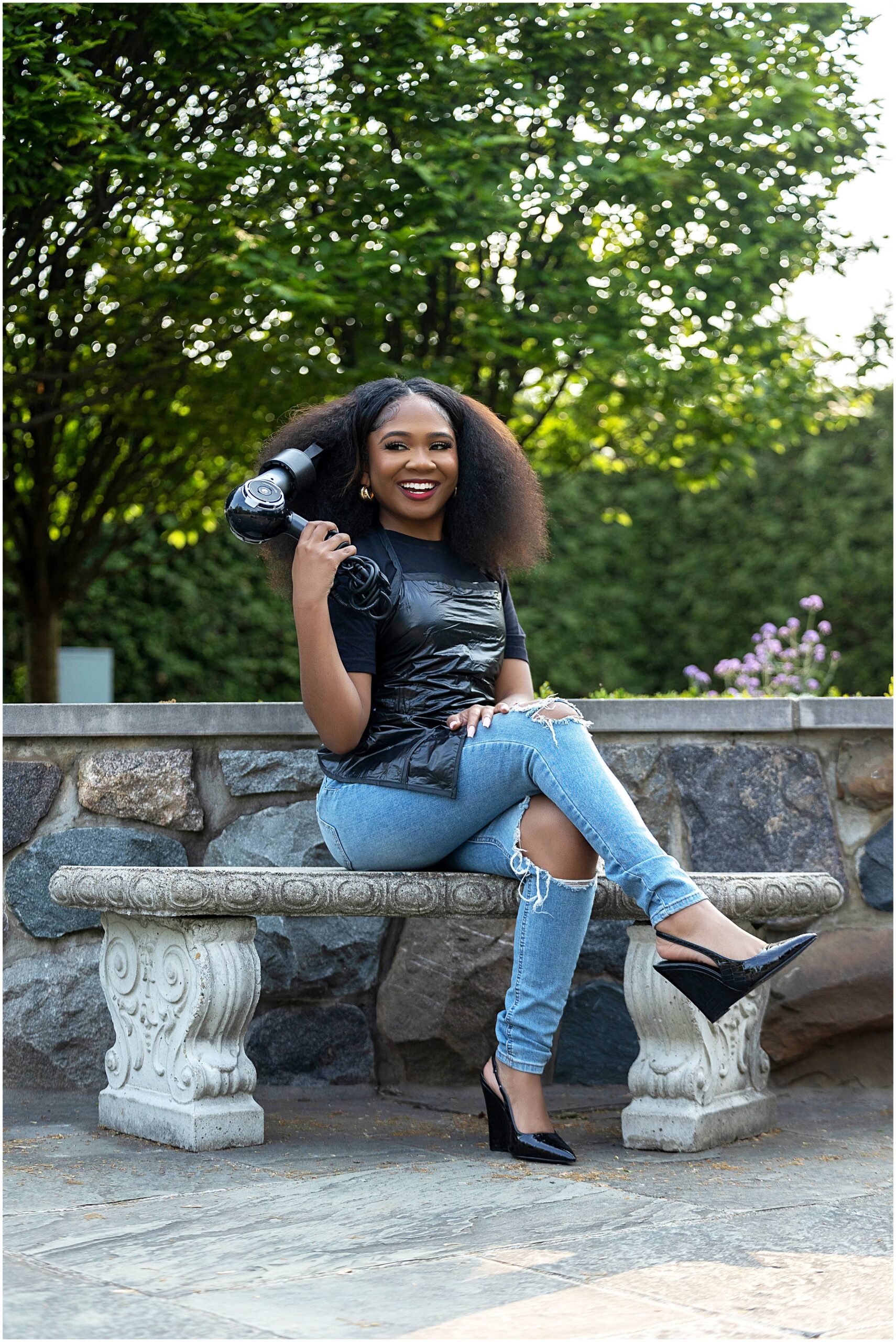 African American girl at Taylor Botanical Gardens sitting on bench posing for senior pictures