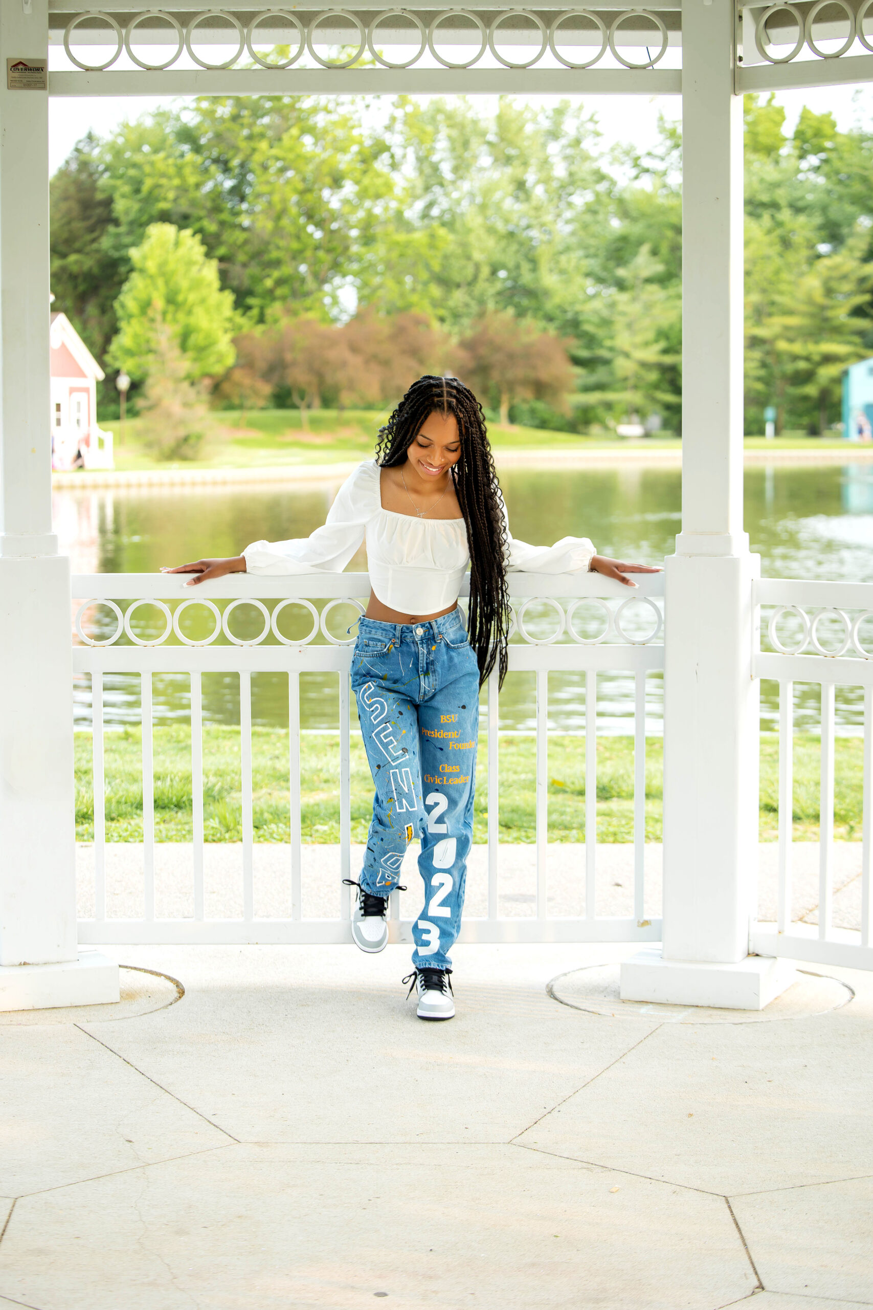 African American girl standing in a gazebo wearing a white blouse and decorated blue jeans in Taylor Heritage Park